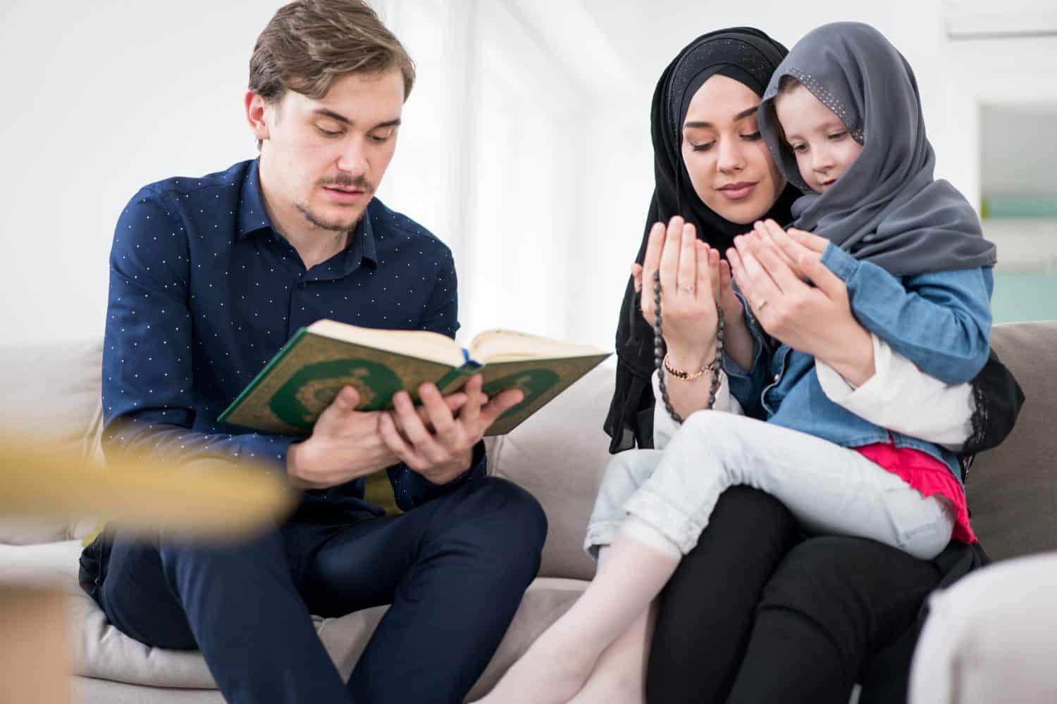 Caucasian Muslim family with little daughter praying together