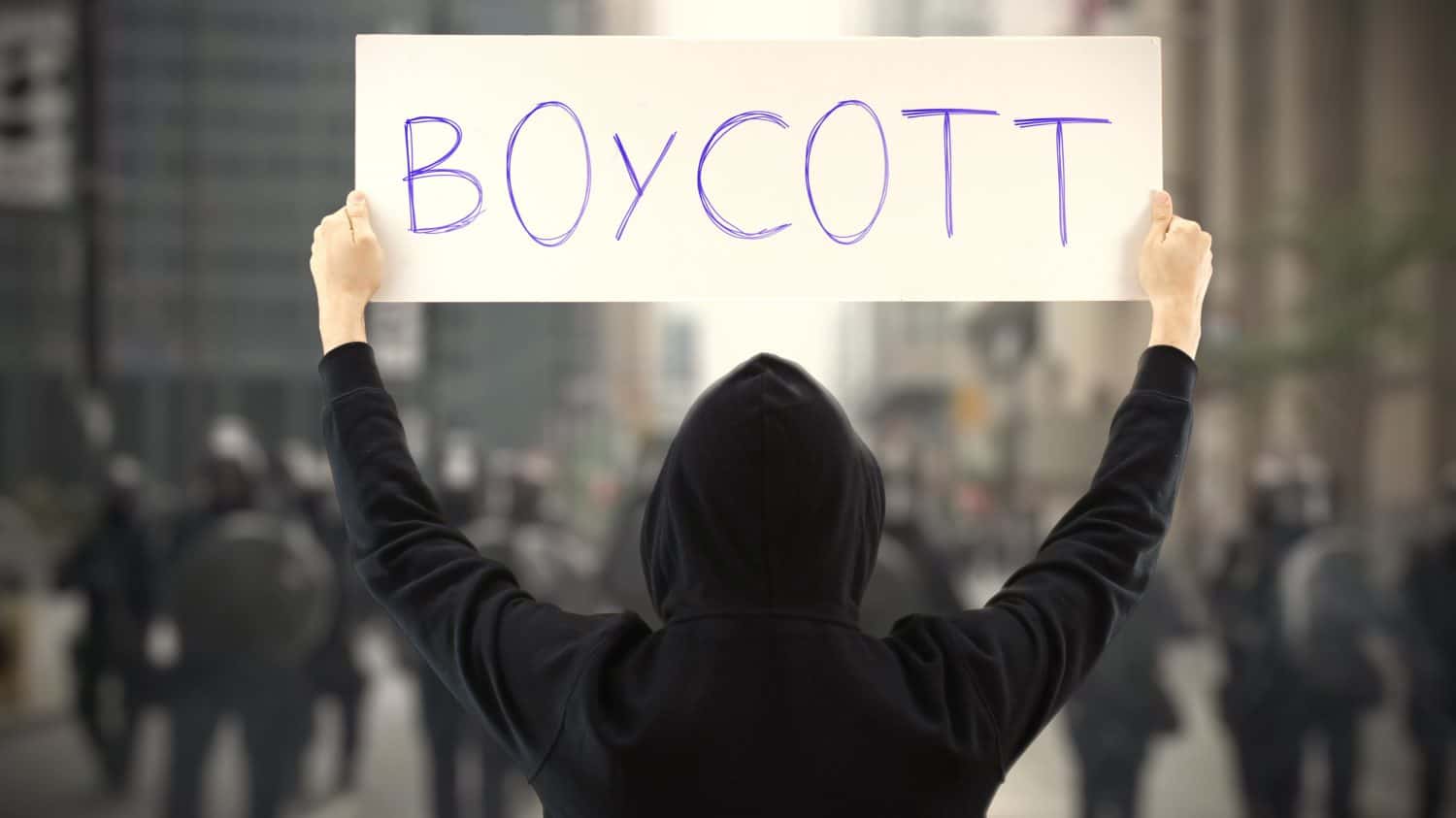 Unknown activist holds a placard with BOYCOTT text