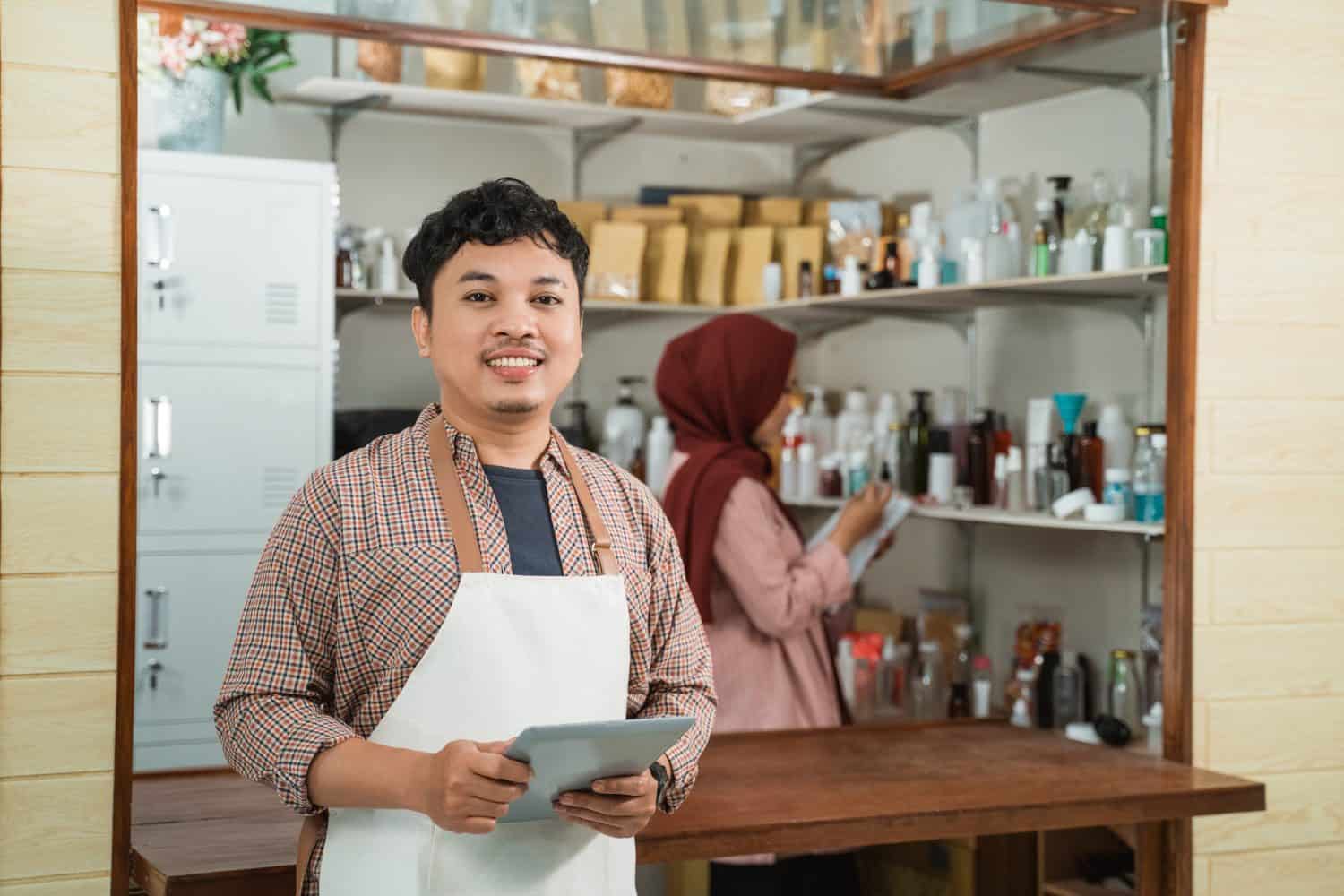 portrait young man and muslim woman selling packaged products