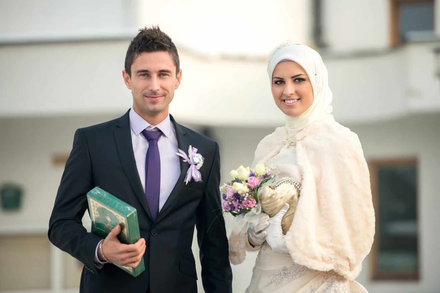 Happy islamic couple posing in front of mosque