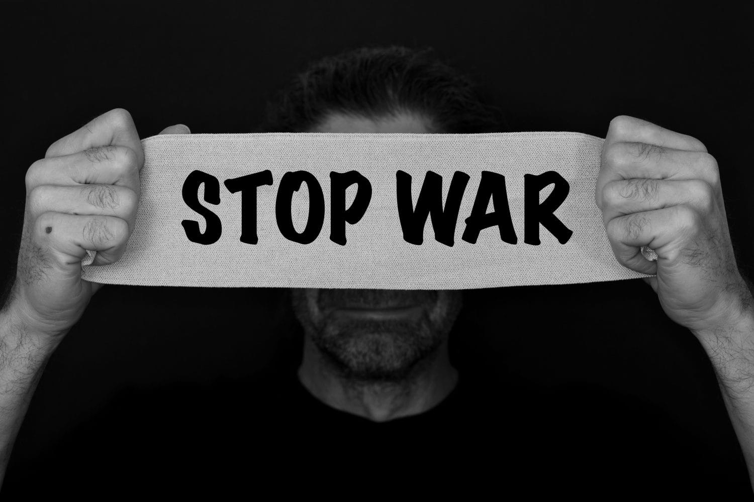 Text message stop war. bearded man with an anxious, fearful expression, with bandage banner in Hand with the text STOP WAR. refugees concept