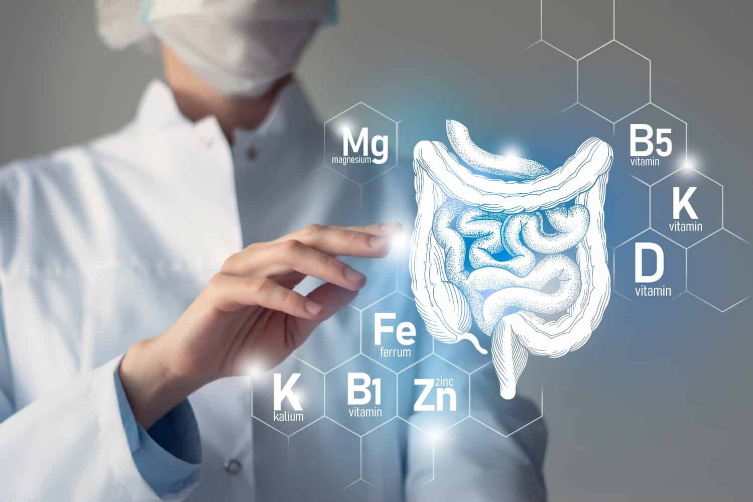 Essential nutrients for Intestine health including Kalium, Ferrum, Magnesium, Vitamin D. Blurred portrait of doctor holding highlighted Intestine.