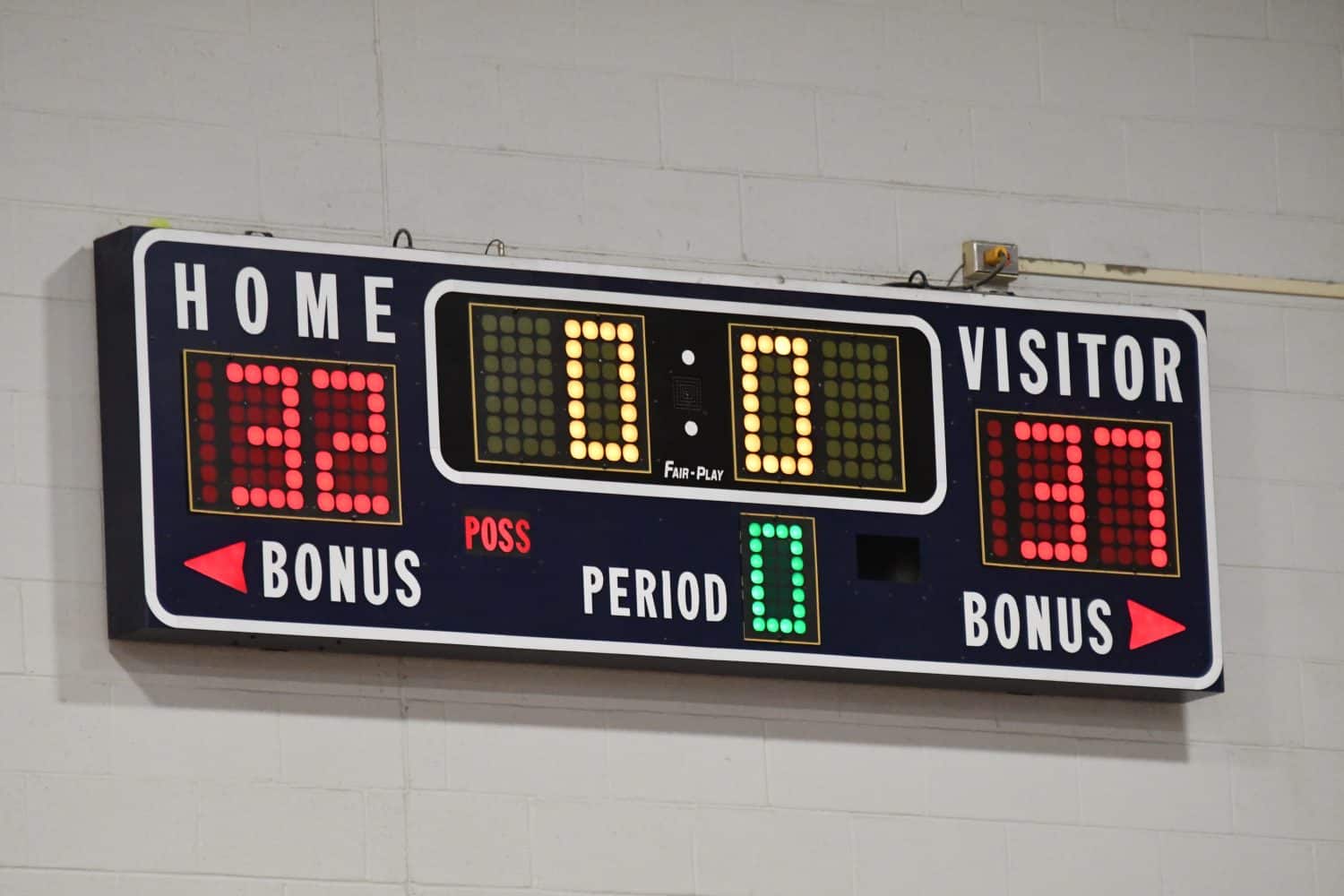 Numbers on a scoreboard on the wall of a gym