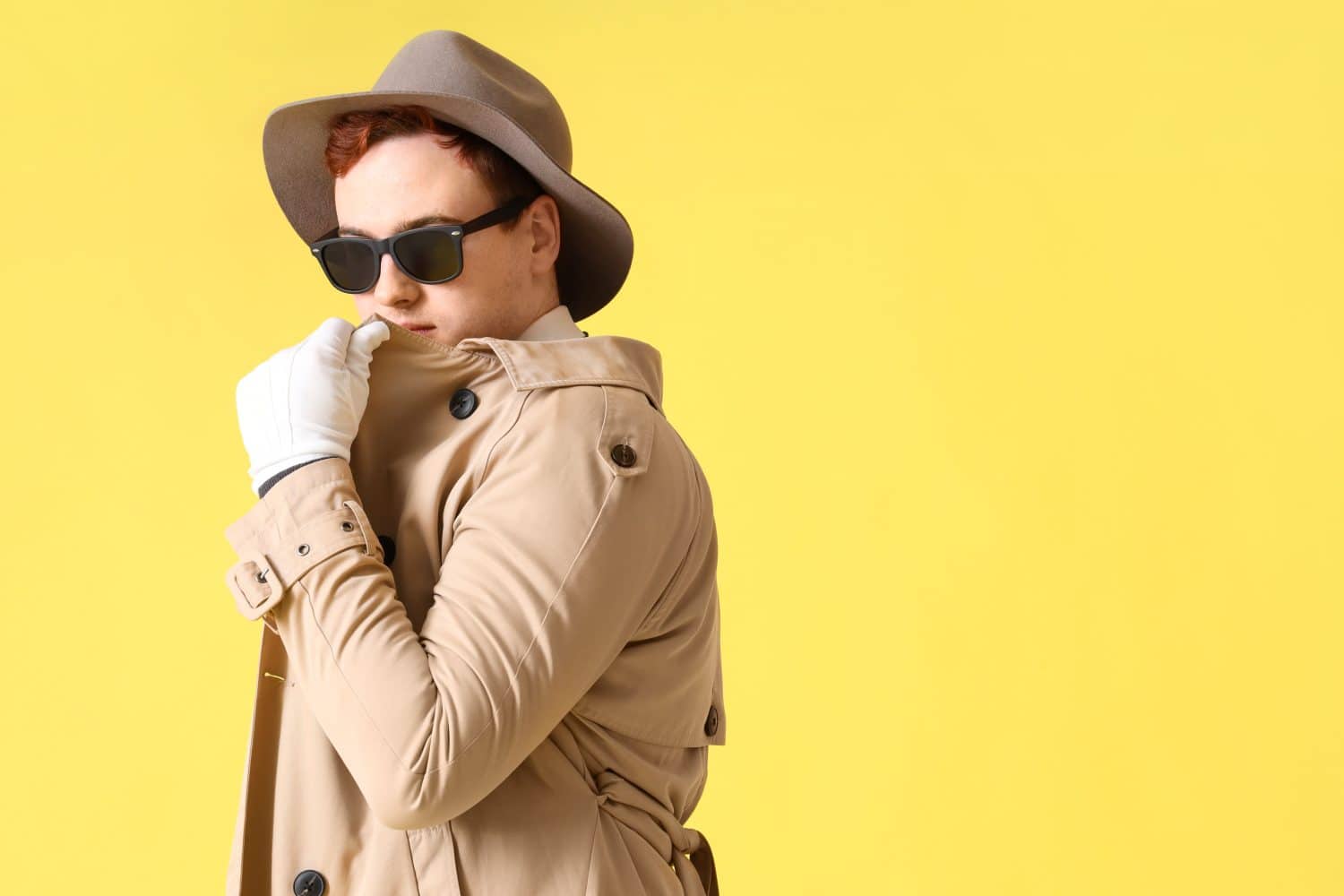 Male spy in disguise on yellow background