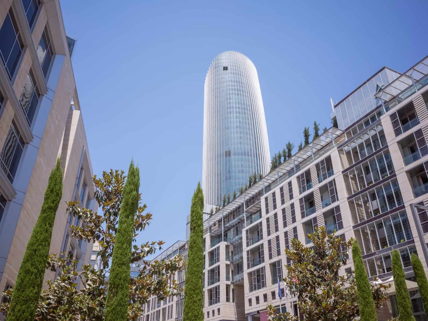 tall building seen between the modern architectures in capital amman