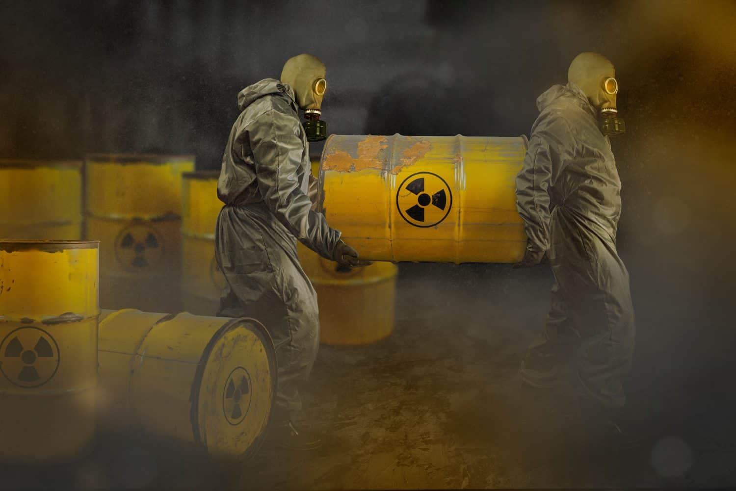 People in a gas masks and protective suits carrying a barrel of nuclear toxic waste. Environmental pollution hazard concept. Dirty air with dust and noise, grunge effect