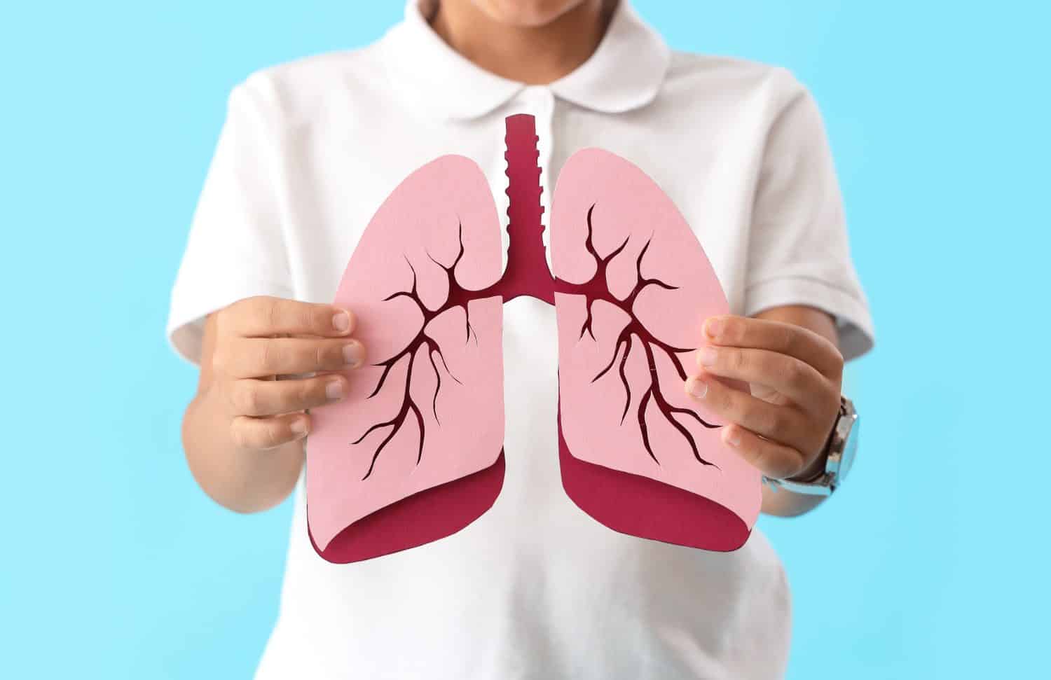 Little boy with paper lungs on blue background, closeup