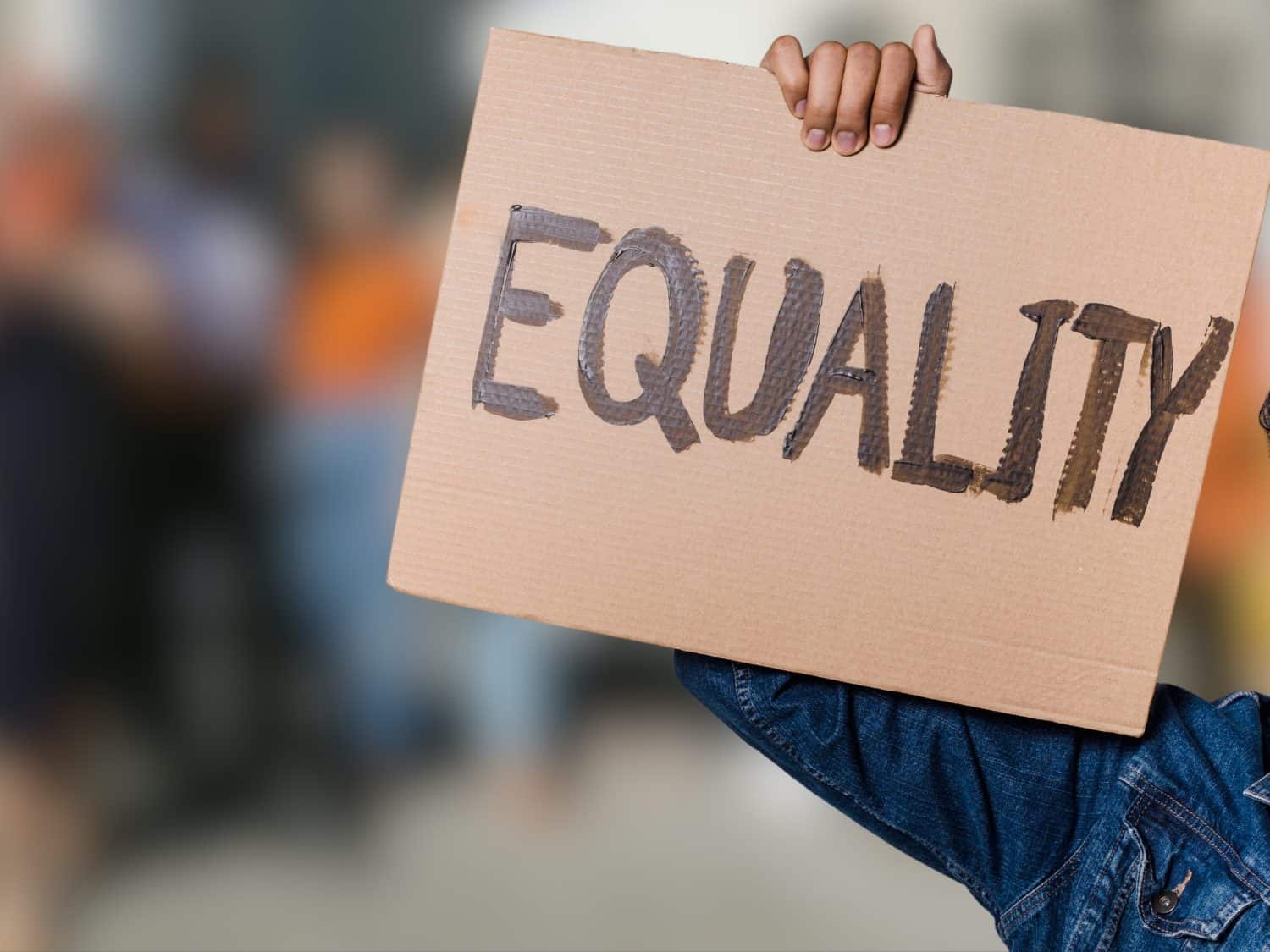 A protester holds up a cardboard sign reading &quot;EQUALITY,&quot; symbolizing the fight for equal rights, justice, and social change.