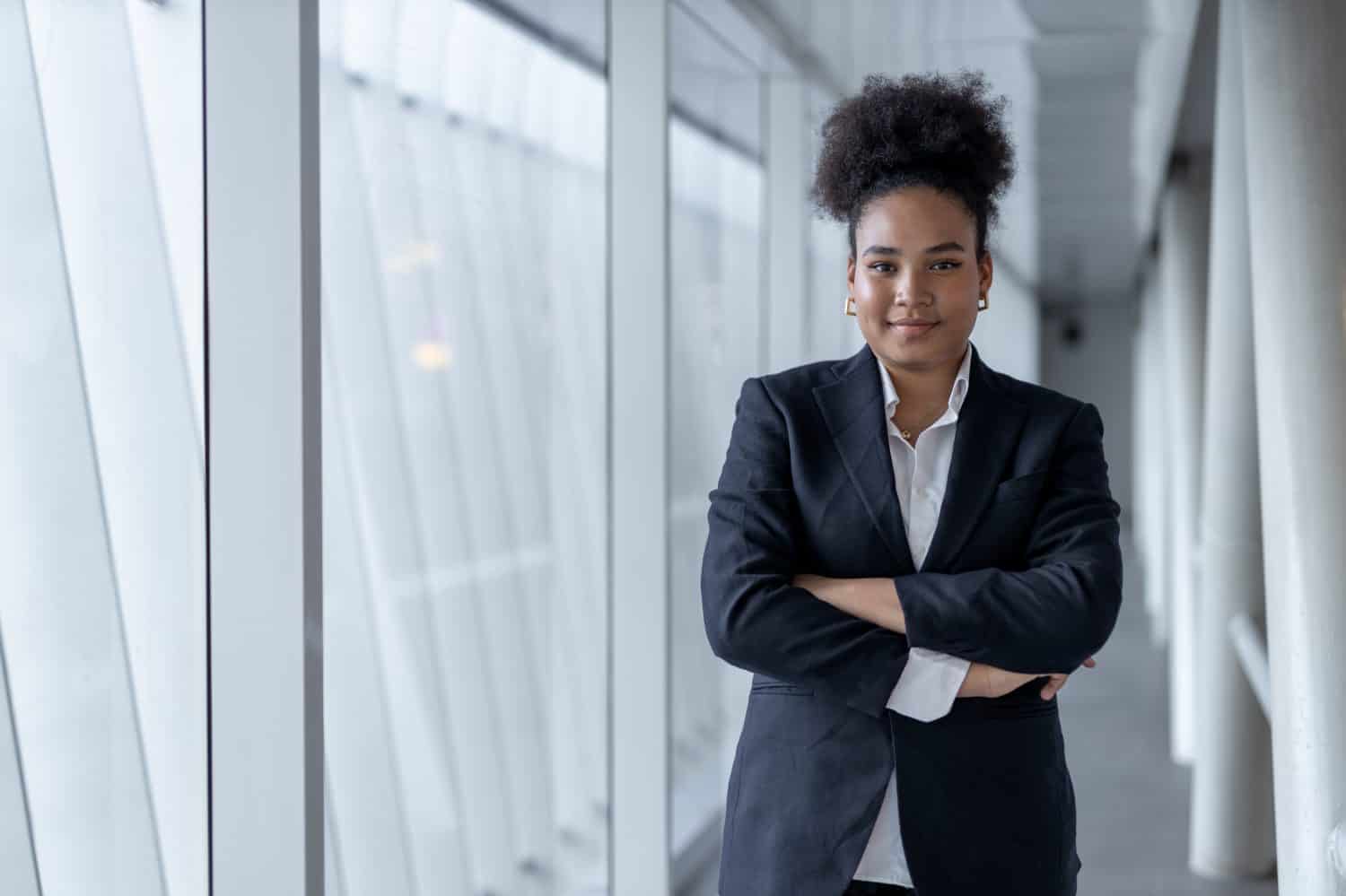 Successful young businesswoman african american black suit crossed arms smiling looking at camera at Office building. business student girl lifestyle. New generation business concept.