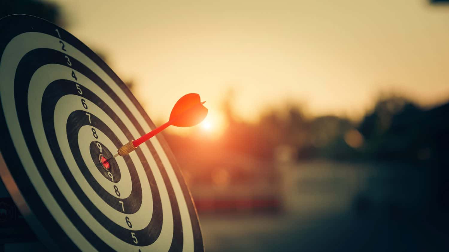 bullseye target or dart board has red dart arrow throw hitting the center of a shooting for business targeting and winning goals business concepts.