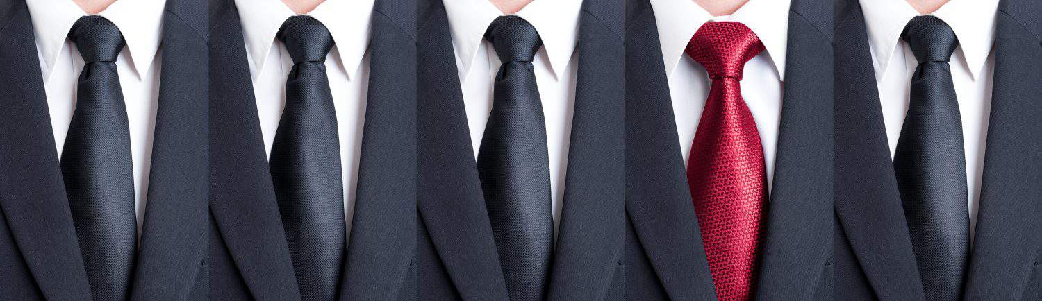 Red tie between black neckties as stand out of the pattern or crowd concept