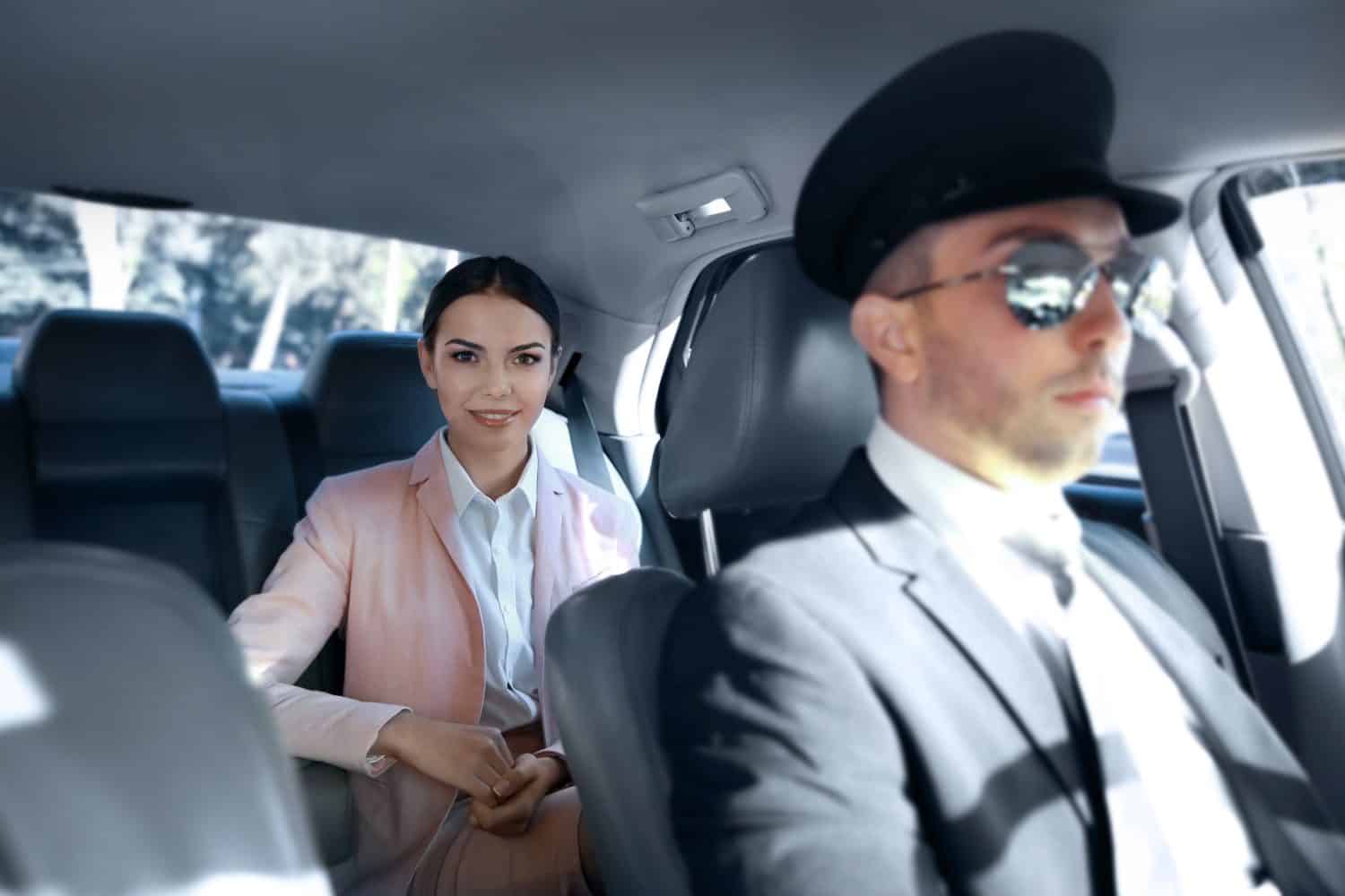 Businesswoman riding a car with chauffeur