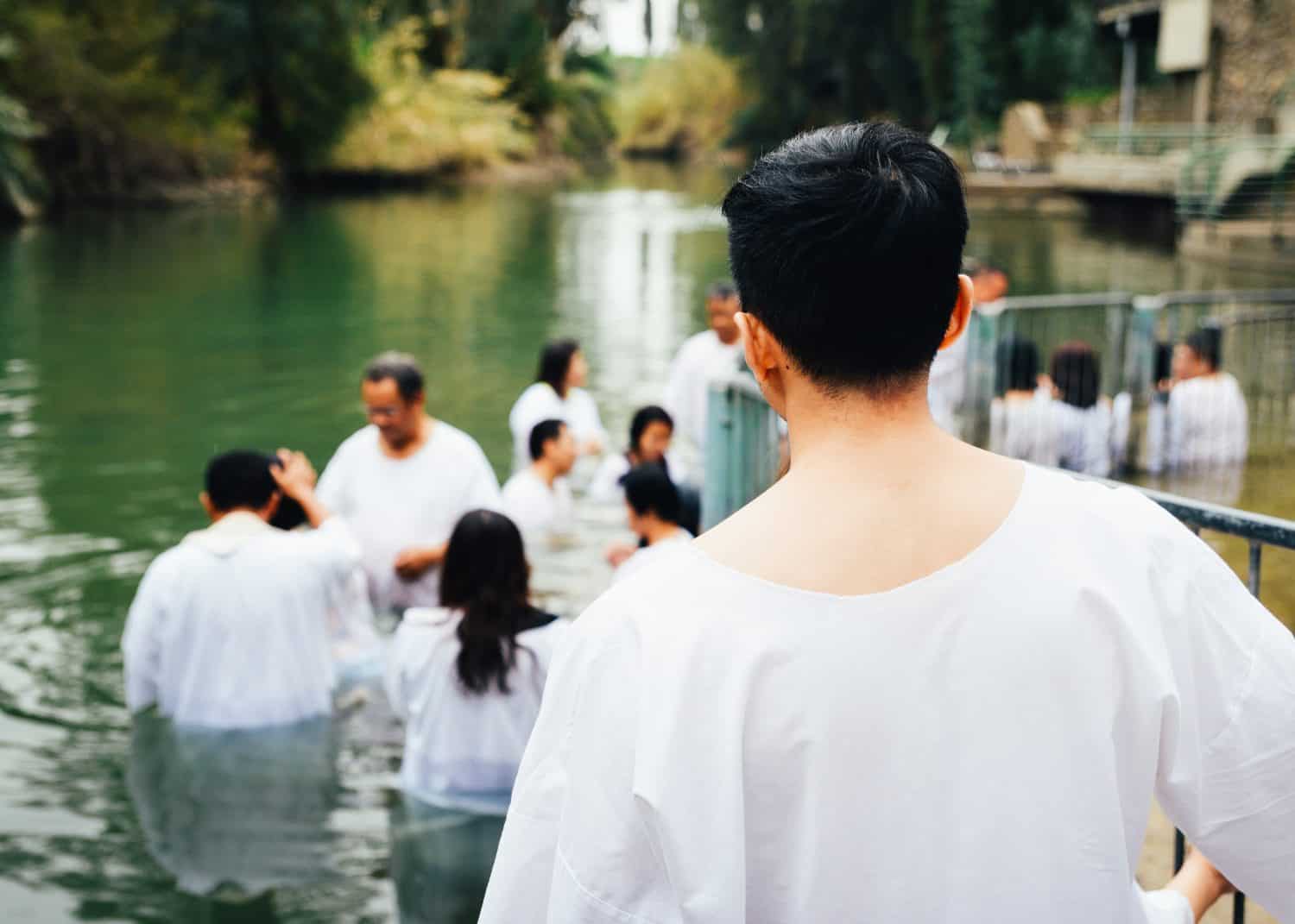 Unidentified Christian pilgrims during mass baptism ceremony at the Jordan River in North Israel (Yardenit Baptismal Site). In Christian tradition, Jesus was baptised in the River Jordan