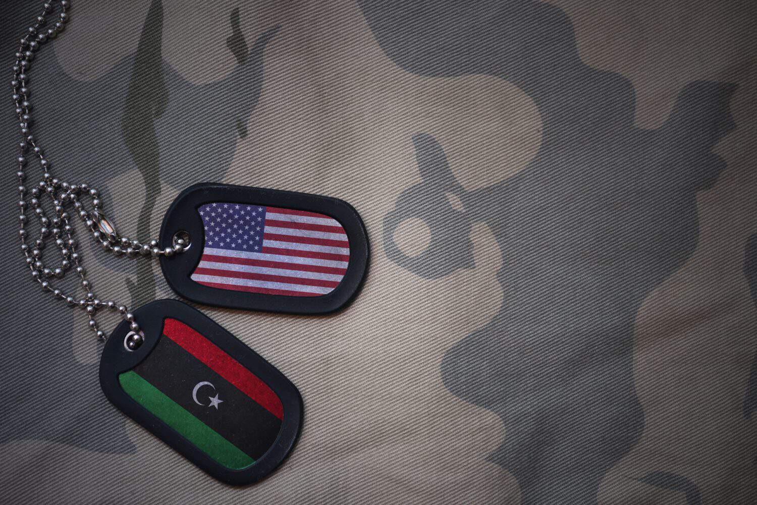 army blank, dog tag with flag of united states of america and libya on the khaki texture background. military concept