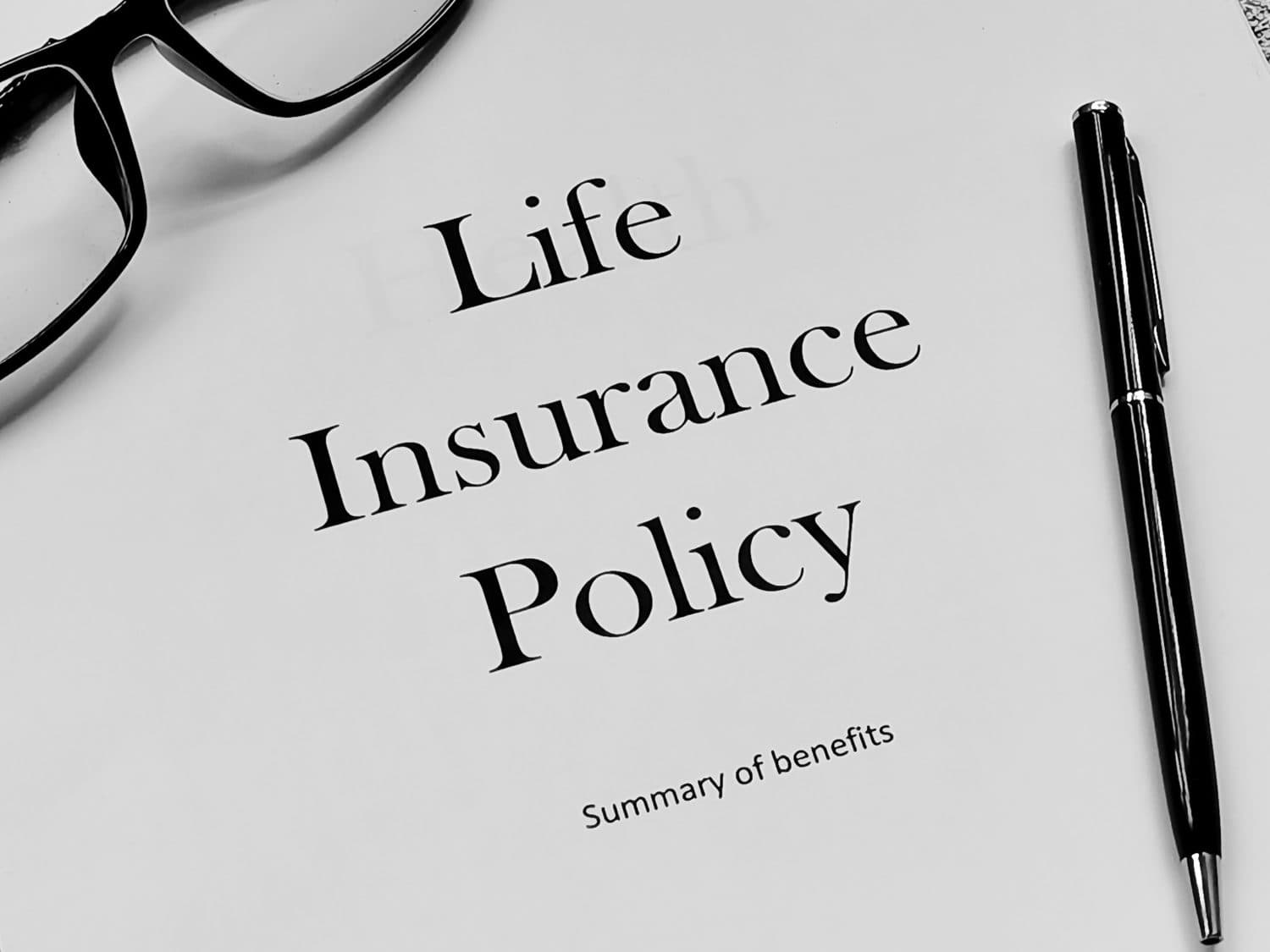 Life Insurance Policy letter with pen,eye glasses and book. Insurance concept.