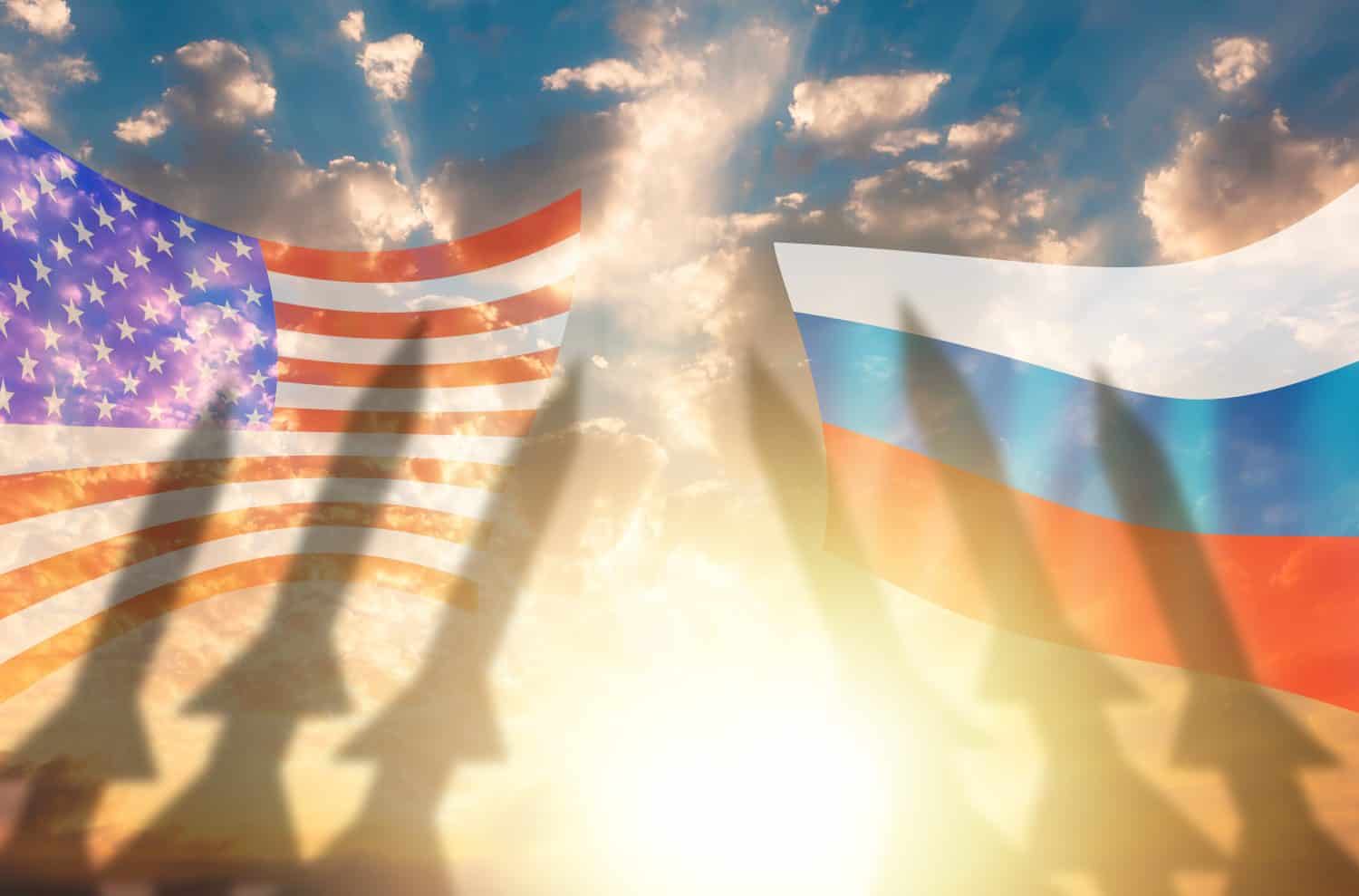 Shadows of missile warheads on the background of Russian and American flags. Sunset in the background. The concept of a military conflict between USA and Russia.