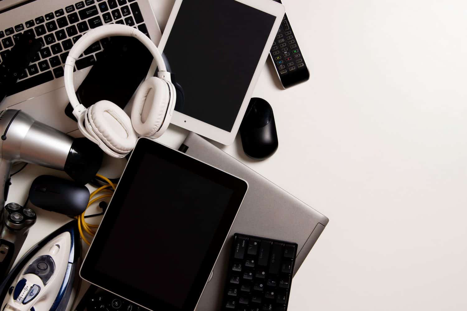 Old computers, digital tablets, mobile phones, many used electronic gadgets devices, broken household and appliances on white background. Planned obsolescence, electronic waste for recycling concept