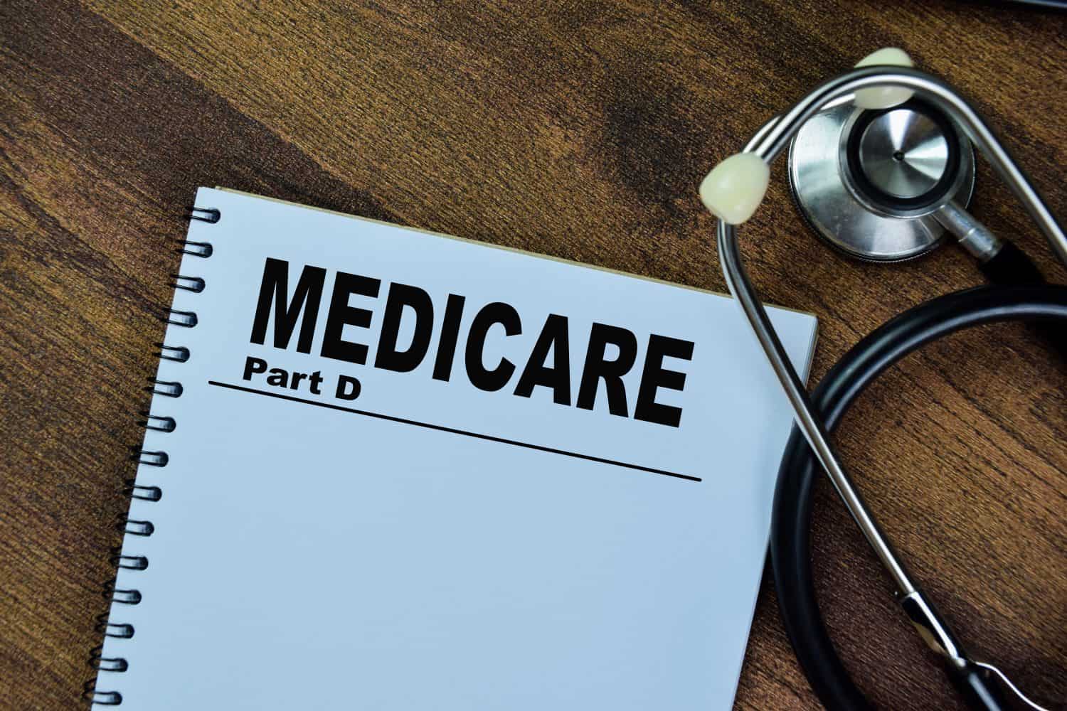 Concept of Medicare Part D write on book with stethoscope isolated on Wooden Table.