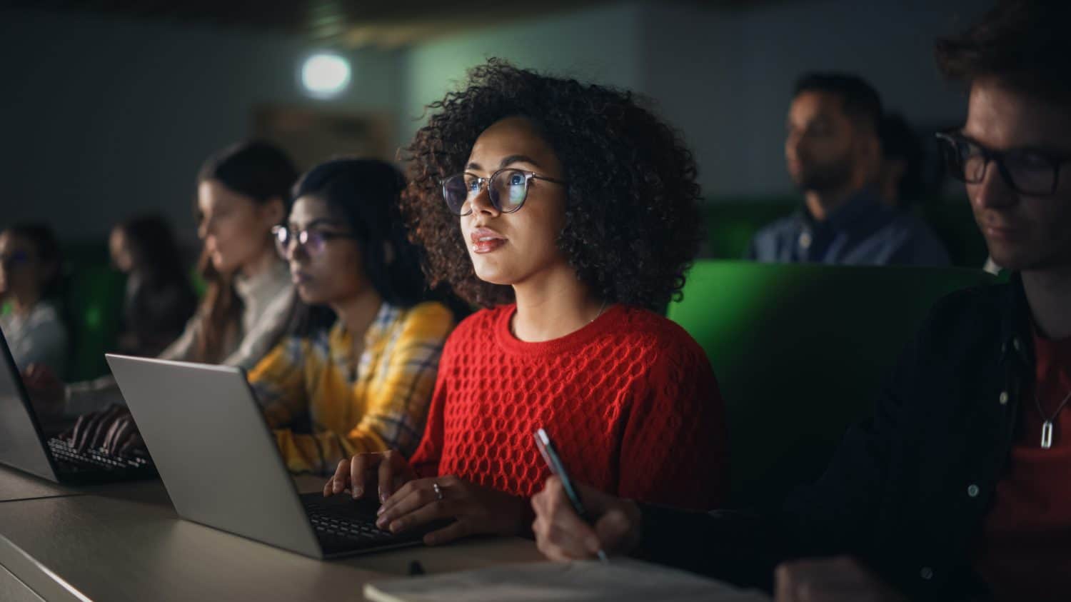 Beautiful Multiethnic African Female Student Studying in University with Diverse Classmates. Young Black Woman Using a Laptop Computer. Applying Her Knowledge to Acquire Academic Skills in Class