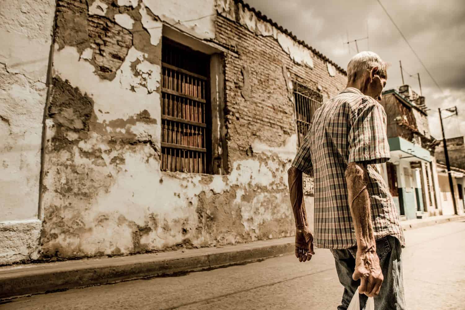 A very thin poor man walking through the streets of Cuba, a sunny and hot afternoon, Cuba, a country that is in extreme poverty.