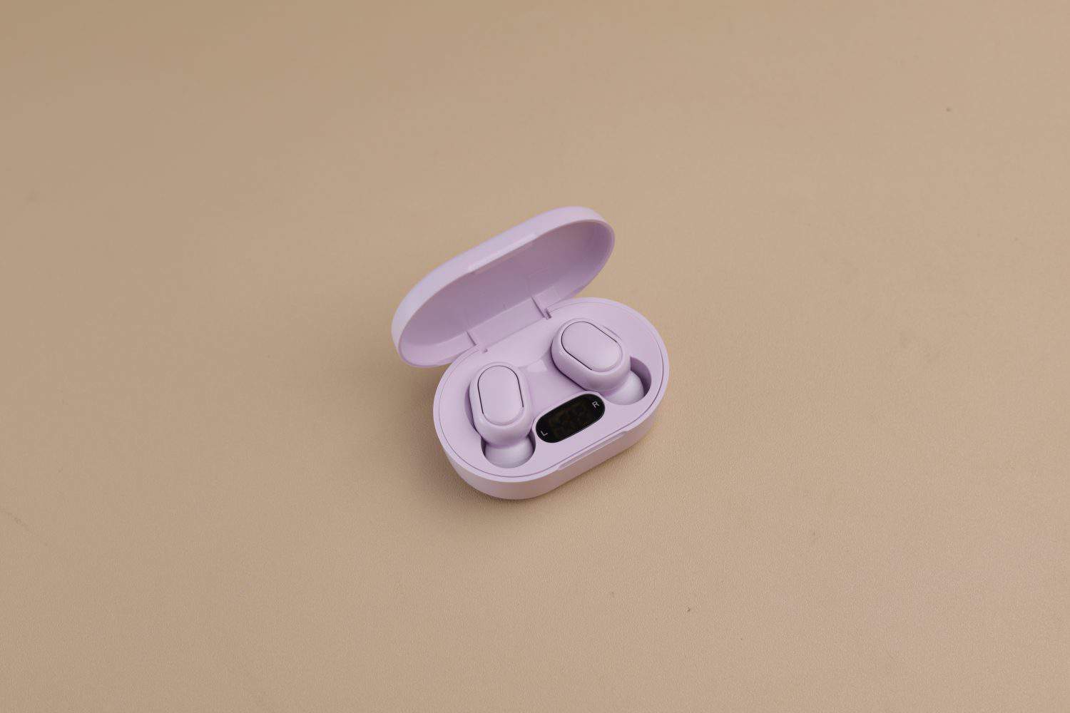 Purple Bluetooth earphone on the table, selective focus and isolated