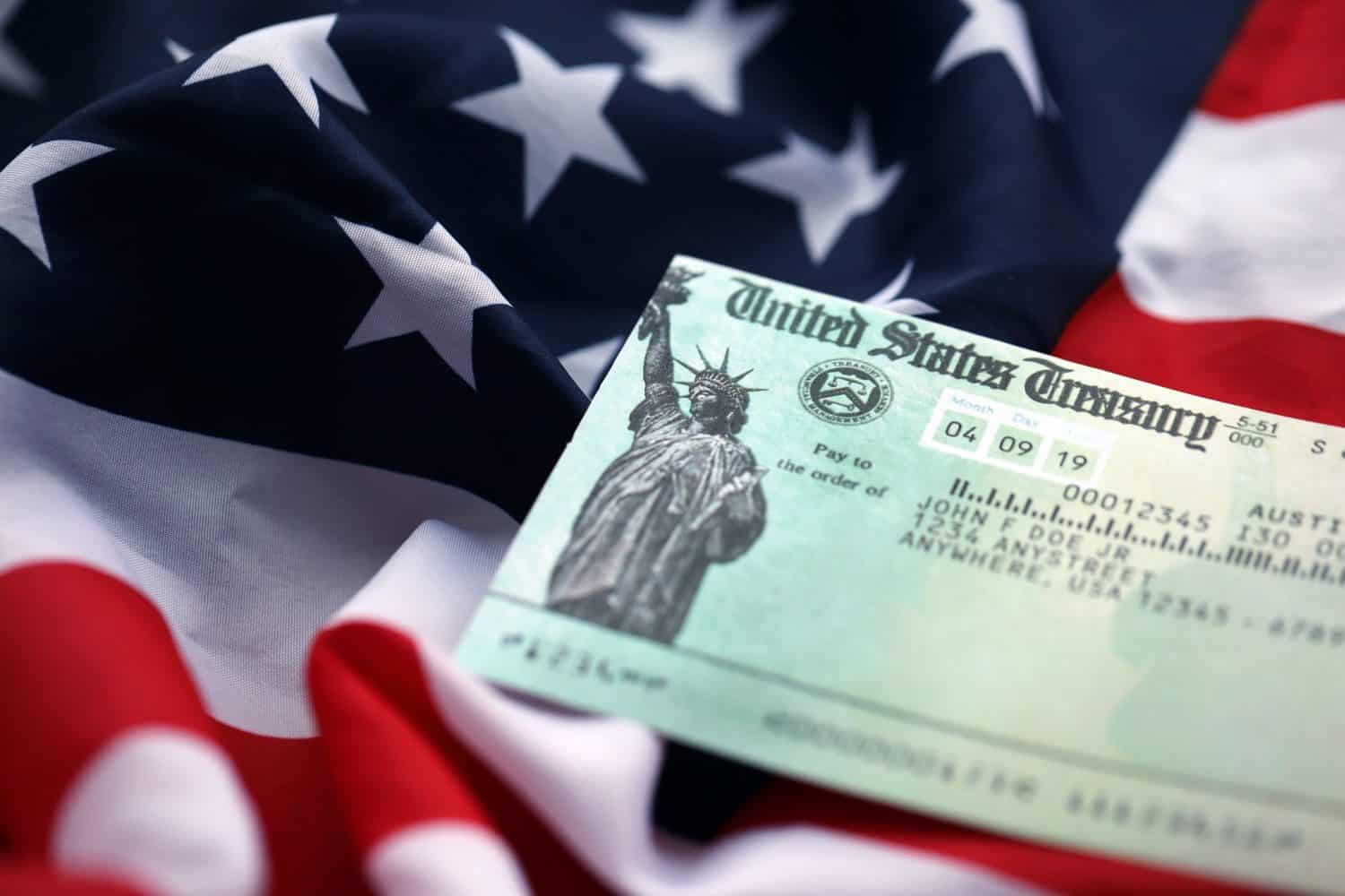 United States Treasury Refund check on waving American Flag close up.