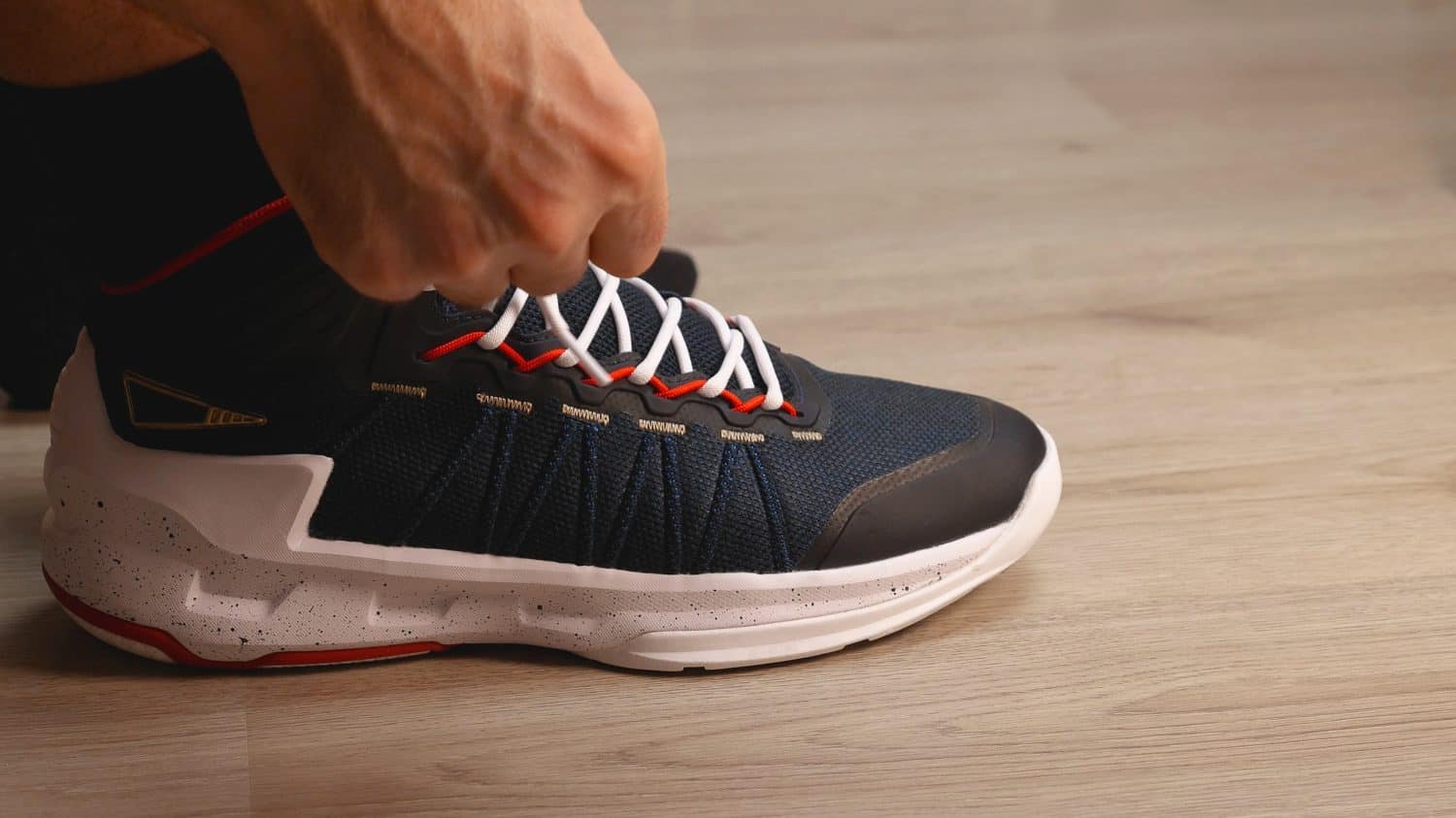 Close-up of black and white basketball shoes. Men&#039;s hands are tying the laces. Preparing for a training session or a walk