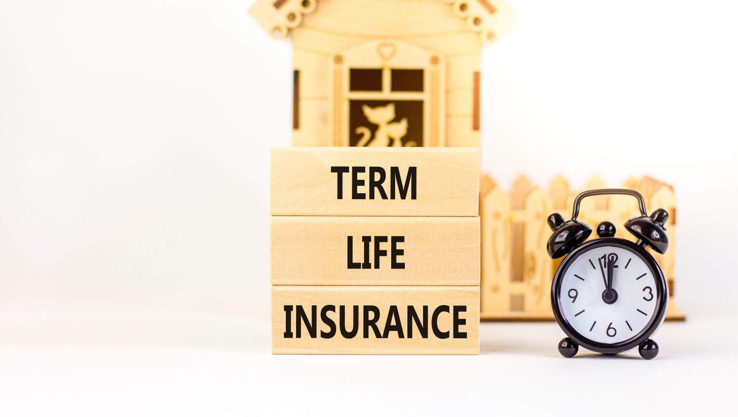 Term life insurance symbol. Concept words Term life insurance on beautiful wooden blocks. Beautiful white table white background. Black alarm clock. Medical term life insurance concept. Copy space.