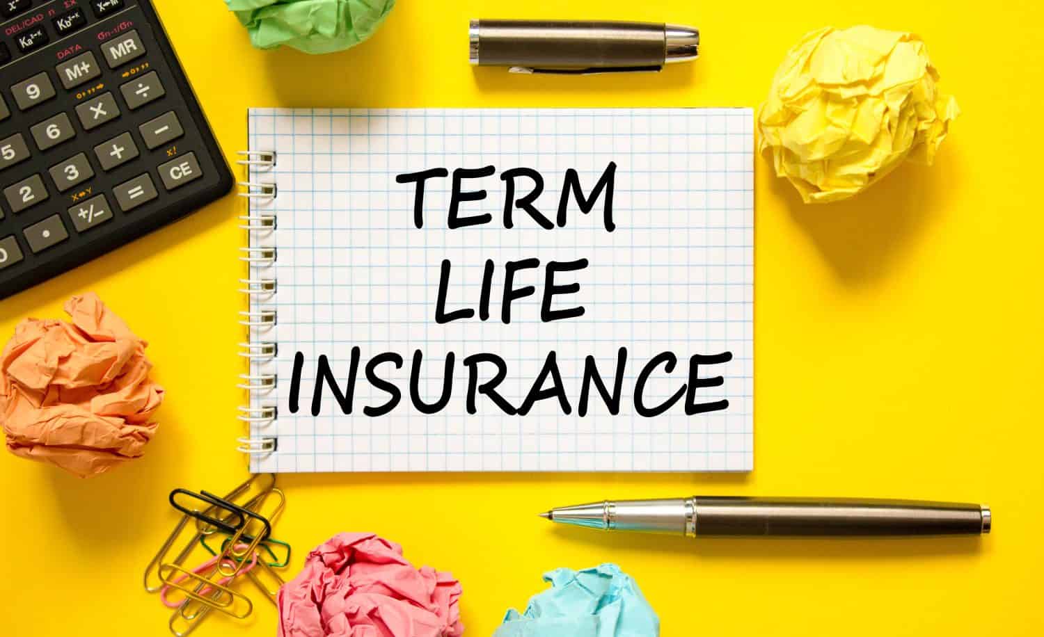 Term life insurance symbol. Concept words Term life insurance on beautiful white note. Beautiful yellow background. Pen. Colored paper. Calculator. Medical term life insurance concept. Copy space.