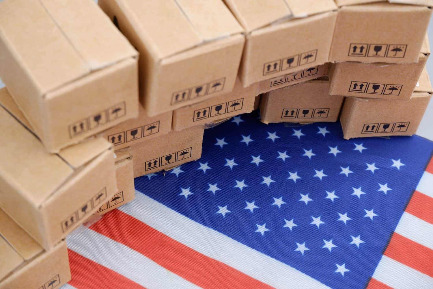 Tariffs and taxes in USA concept. Many carton boxes on US flag.