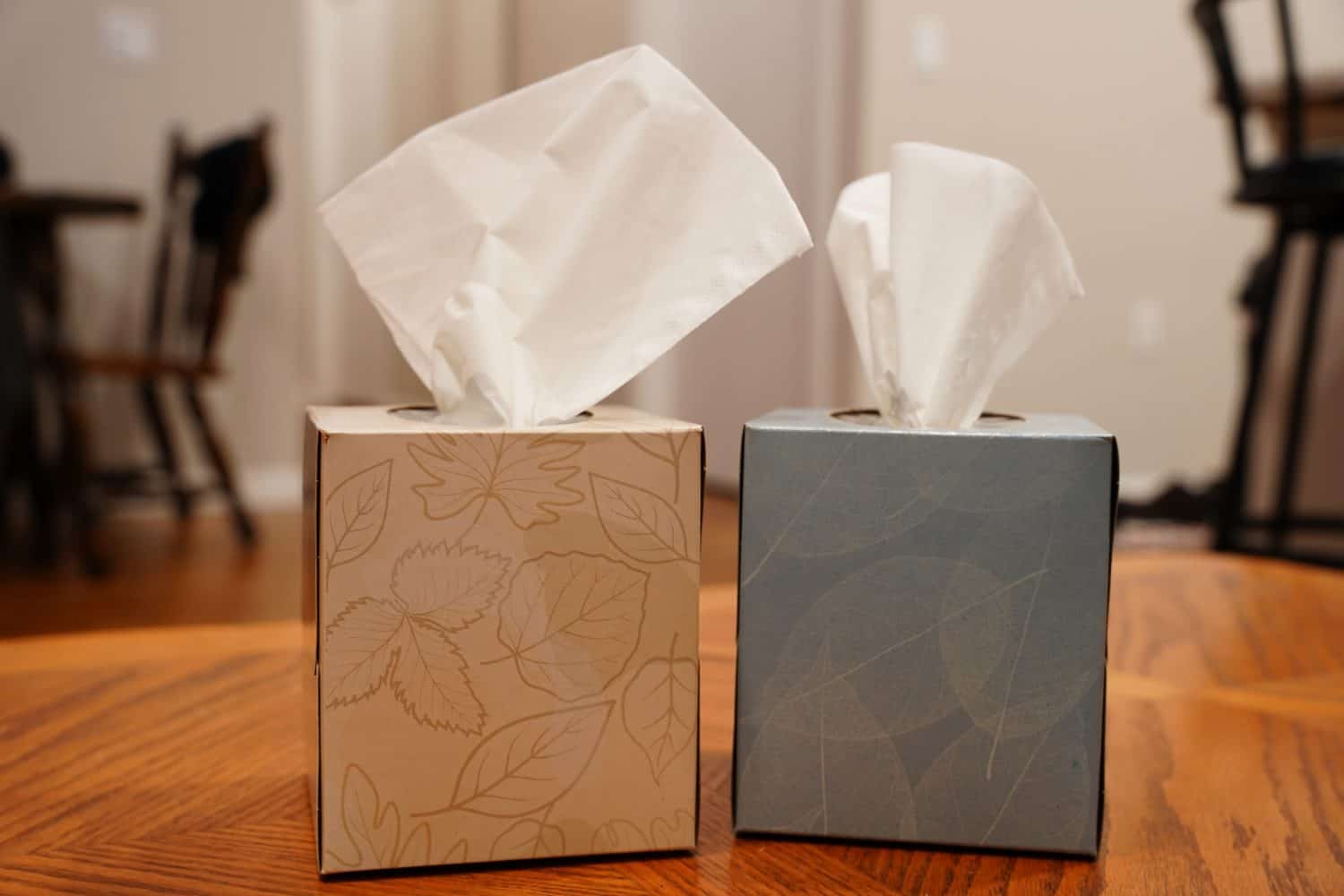 Boxes of Kleenexs sit on a coffee table.