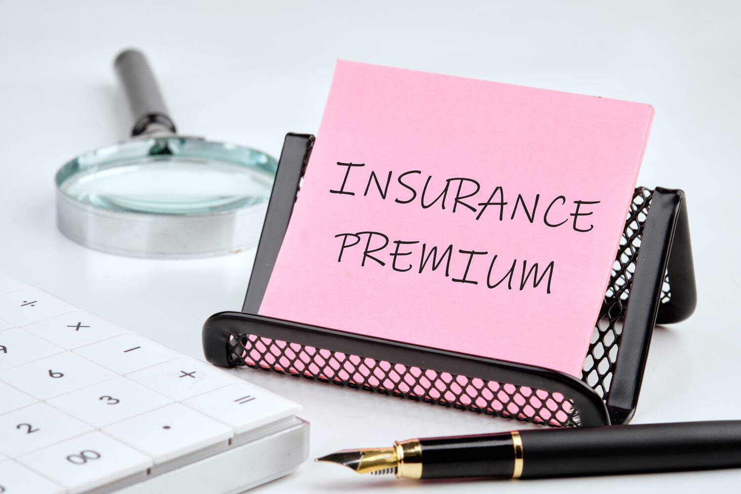 Business concept. INSURANCE PREMIUM text written on a pink sticker on a black stand on a white background