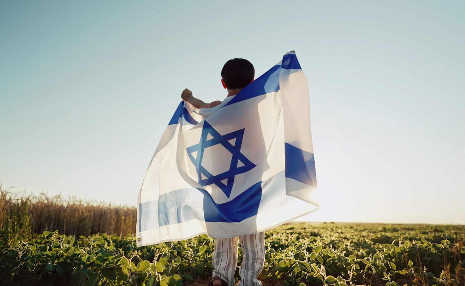 Happy Israeli Jewish Little Boy Jumping, Israel National Flag. Independence Day. Patriotism. Symbol of democracy, independence, future. High quality