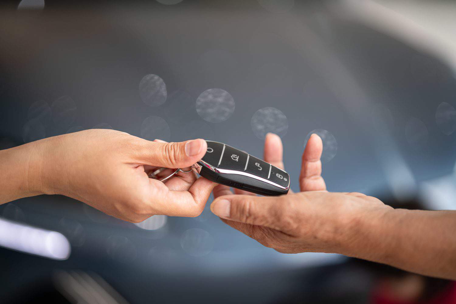 Action of human hands are giving and taking a car key. Buying the new car or car rental business concept scene, Close-up and selective focus at the object.