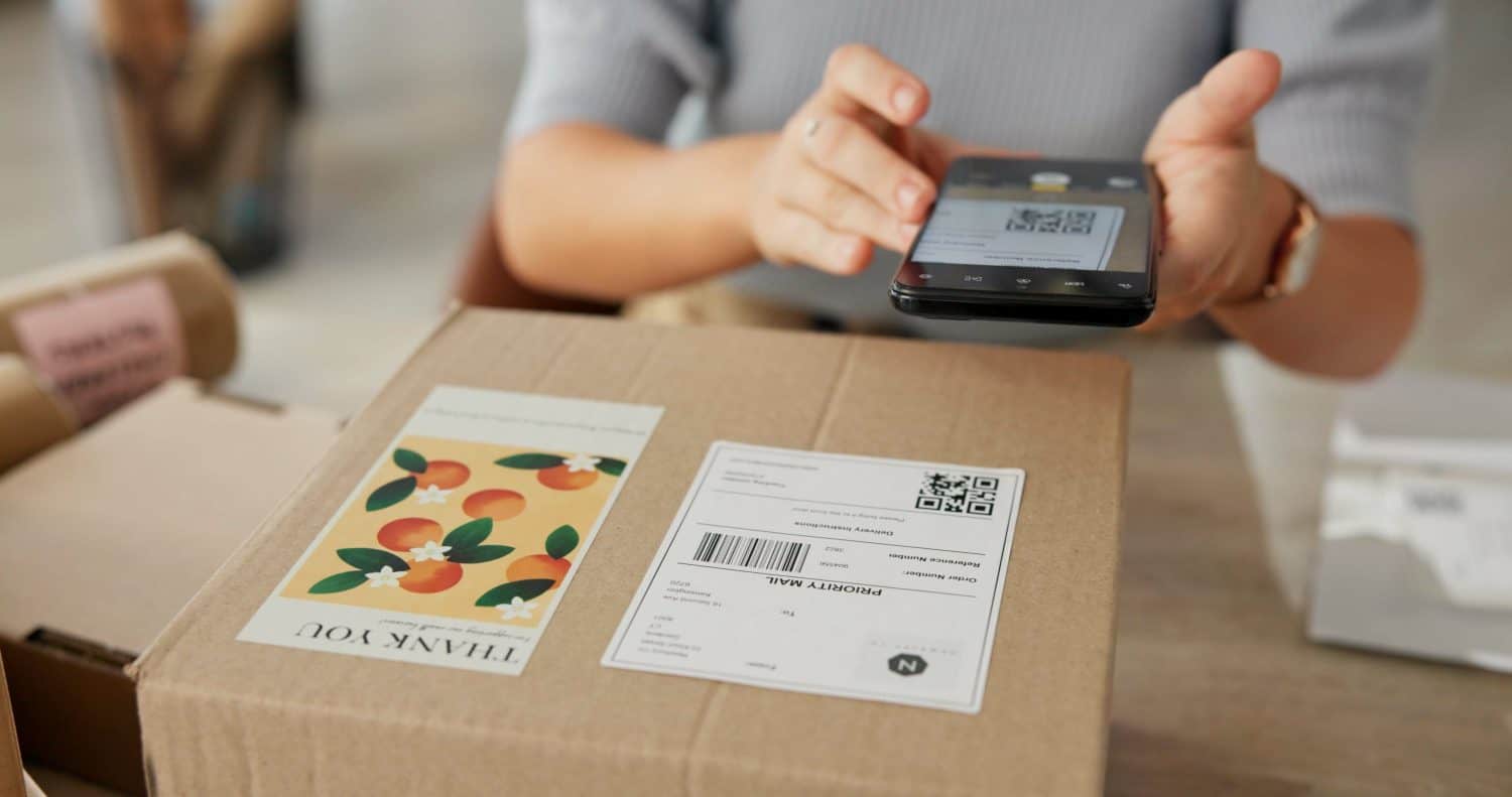 Woman, hands and phone to scan package for dropshipping, online information and parcel distribution. Owner, mobile or logistics for supply chain, check barcode and supplier invoice of retail delivery