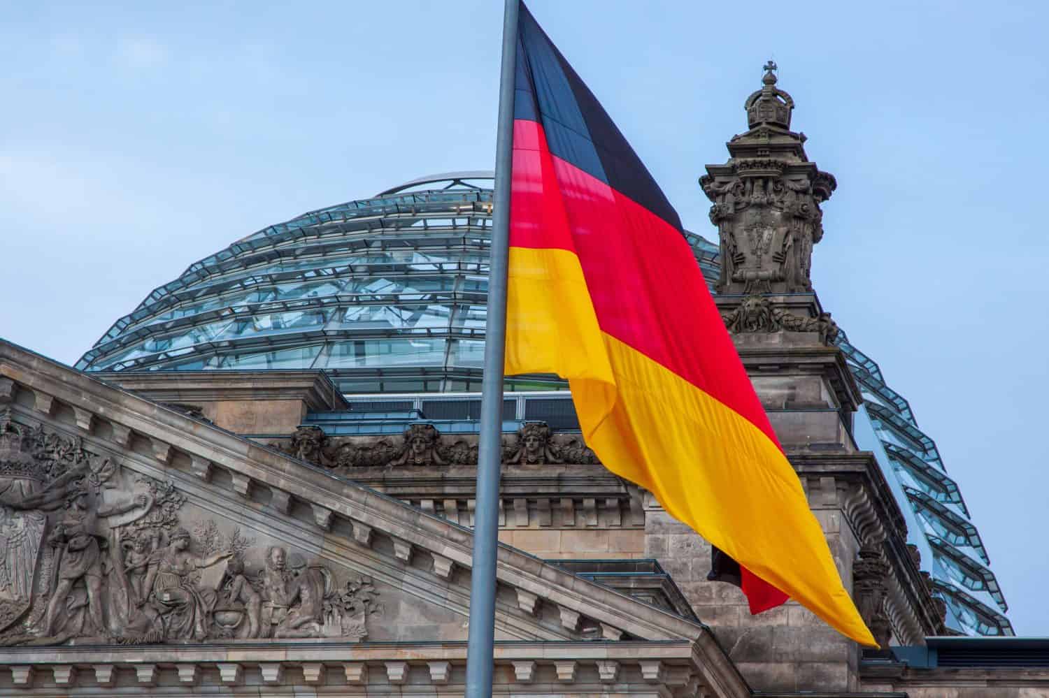 Reichstag building in Berlin, Germany, with the German flag flying.