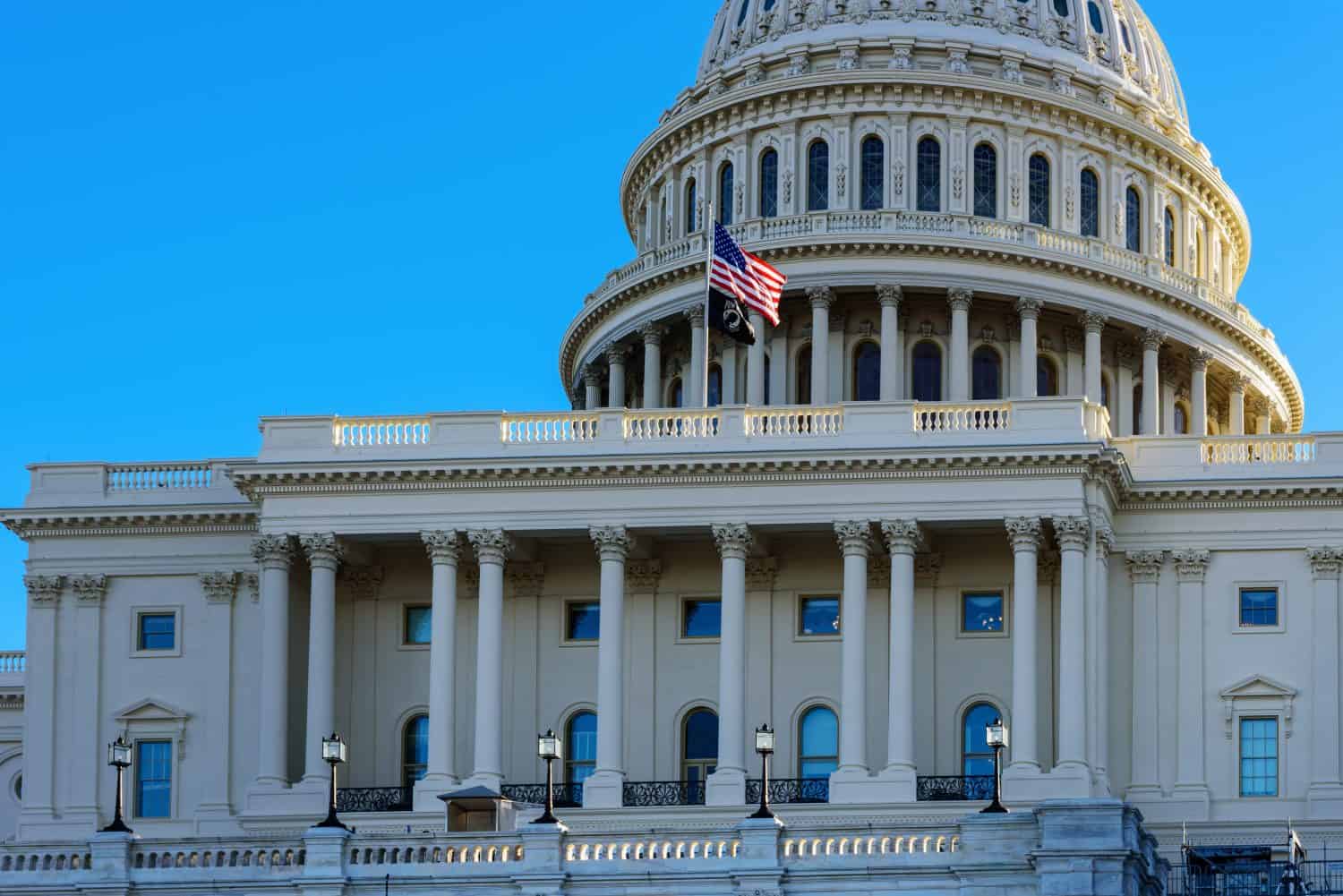Close-up of the United States flag in front of the Capitol Building's dome in the morning, Washington, D.C.