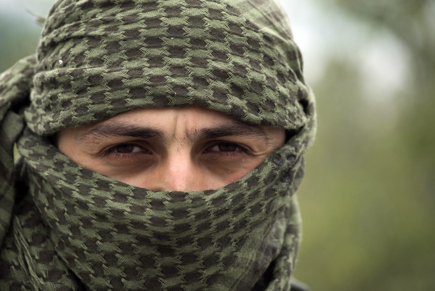 Close up of young guy in shemag. Keffiyeh - traditional Arabic headgear. Portrait of soldier