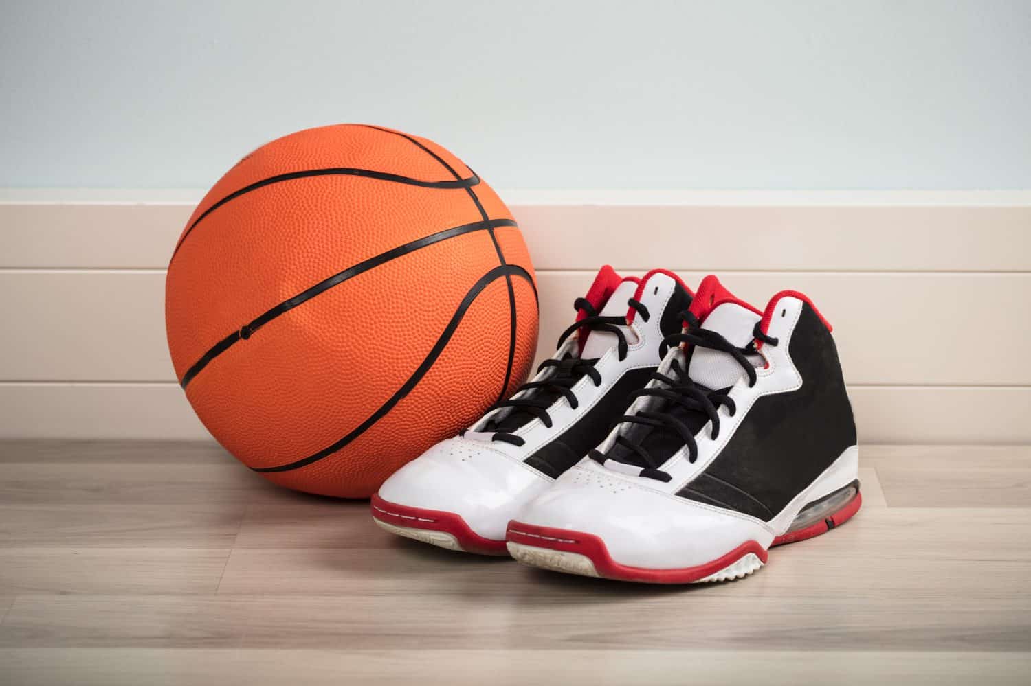 Sport Shoes And A Basketball On Hardwood Floor