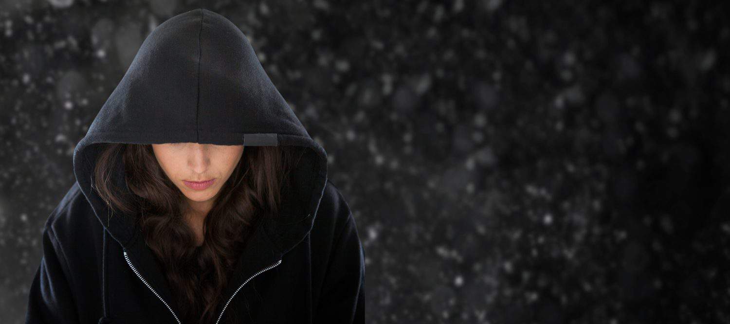 Female spy in hoodie against black background