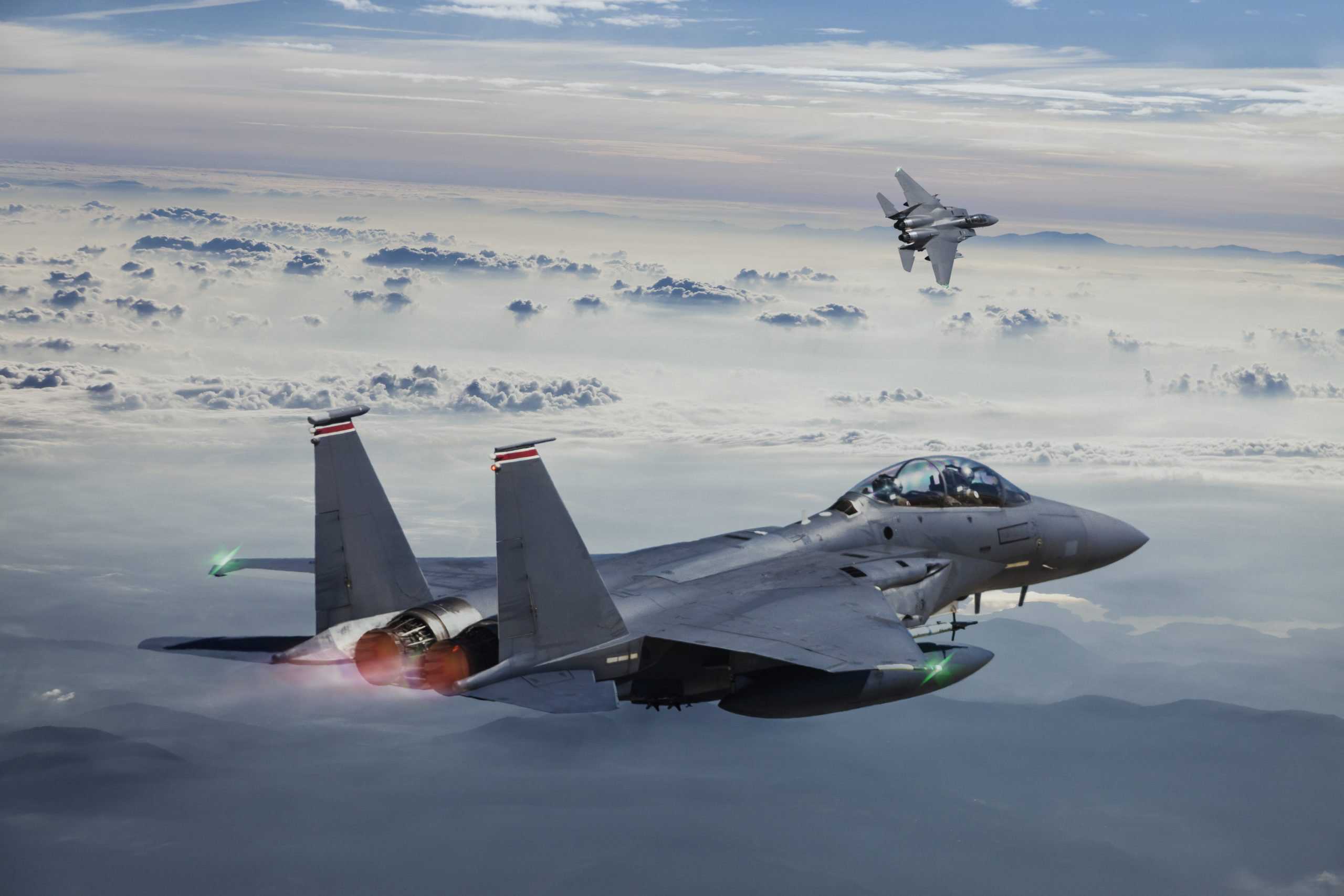 F-15 Eagle Fighter Jets in Flight with afterburner above the fogy mountains