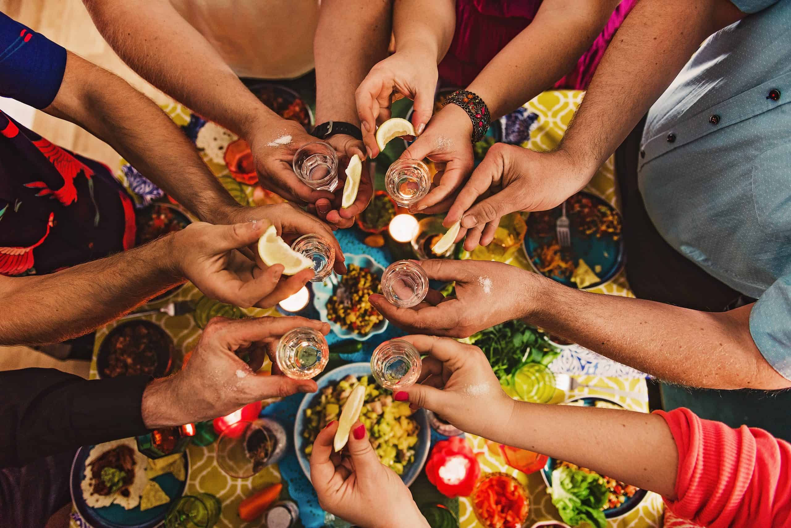 Friends drinking tequila at dinner party