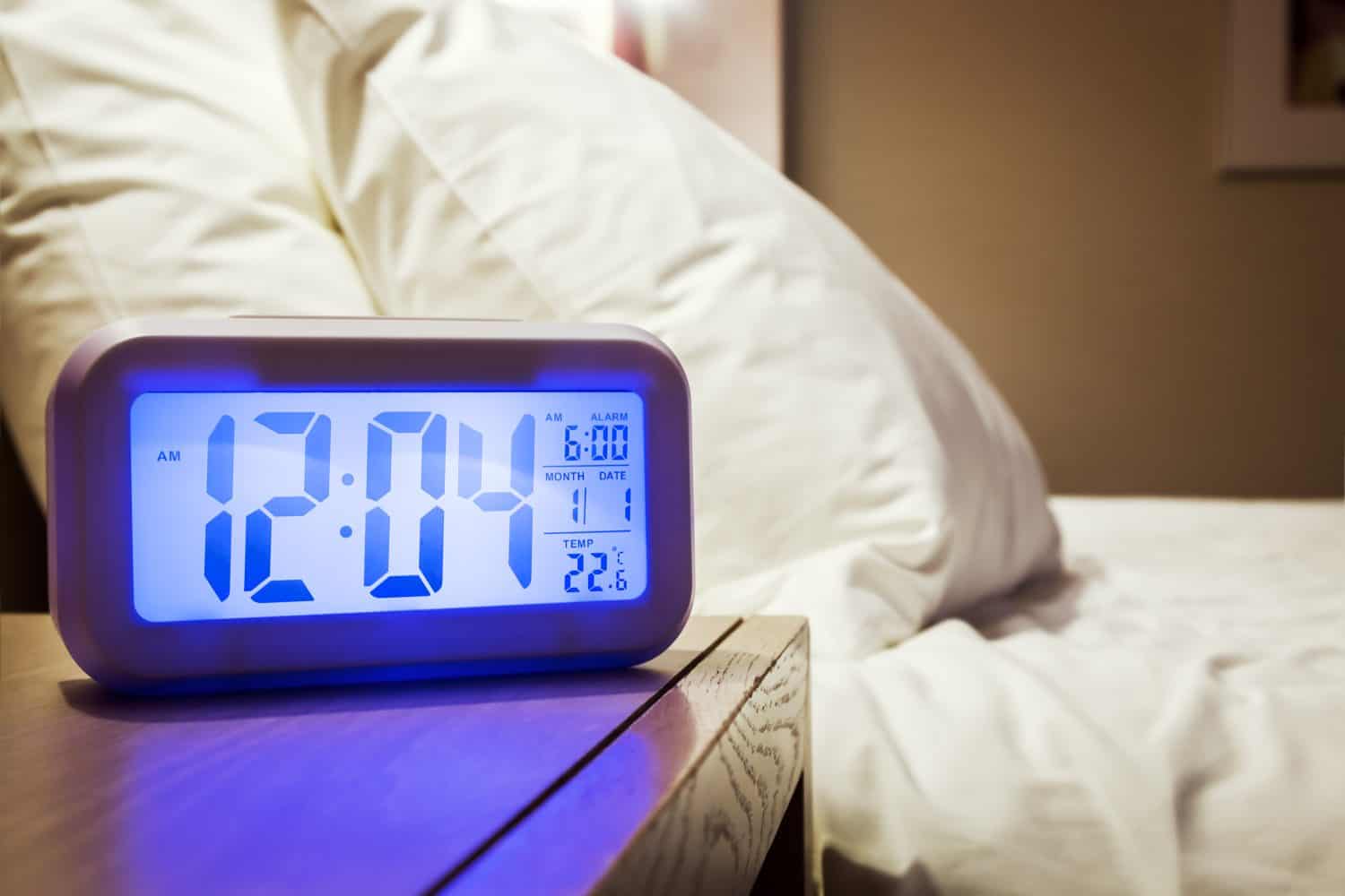 electronic alarm clock stands on a bedside table in the room or hotel room