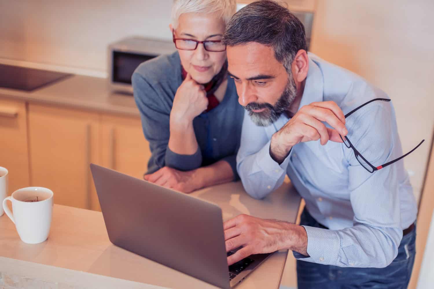 Mature couple watching something on laptop at home.