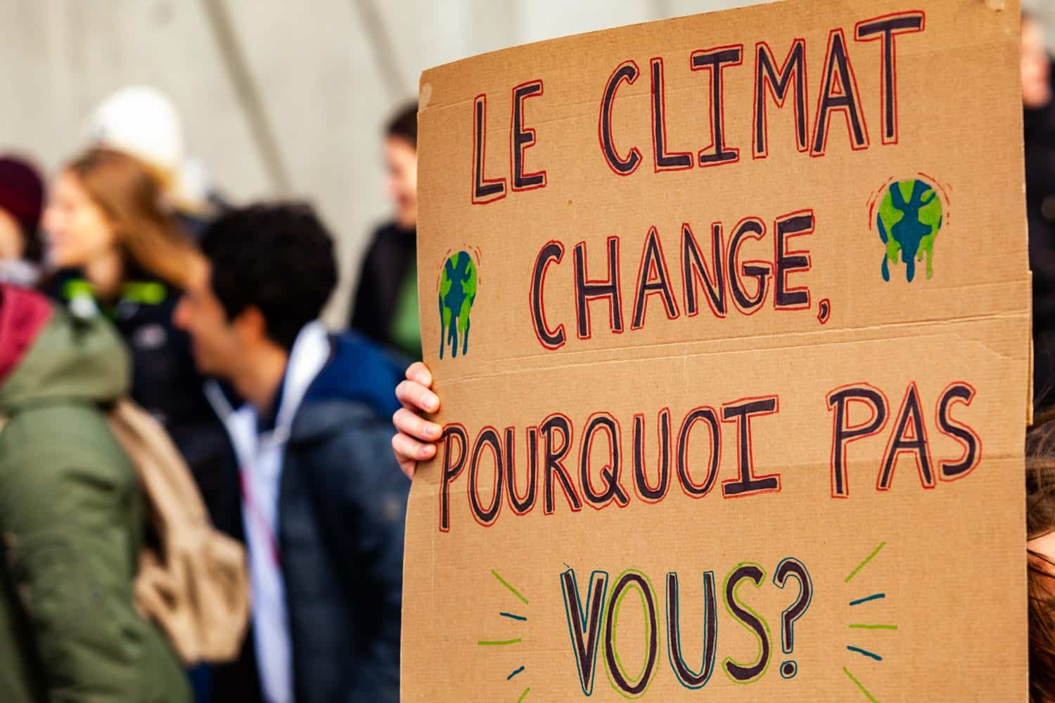 French sign at environmental protest. A French poster is viewed close-up, saying the climate is changing, why not you, as during an ecological activism march on a street in Montreal, Canada