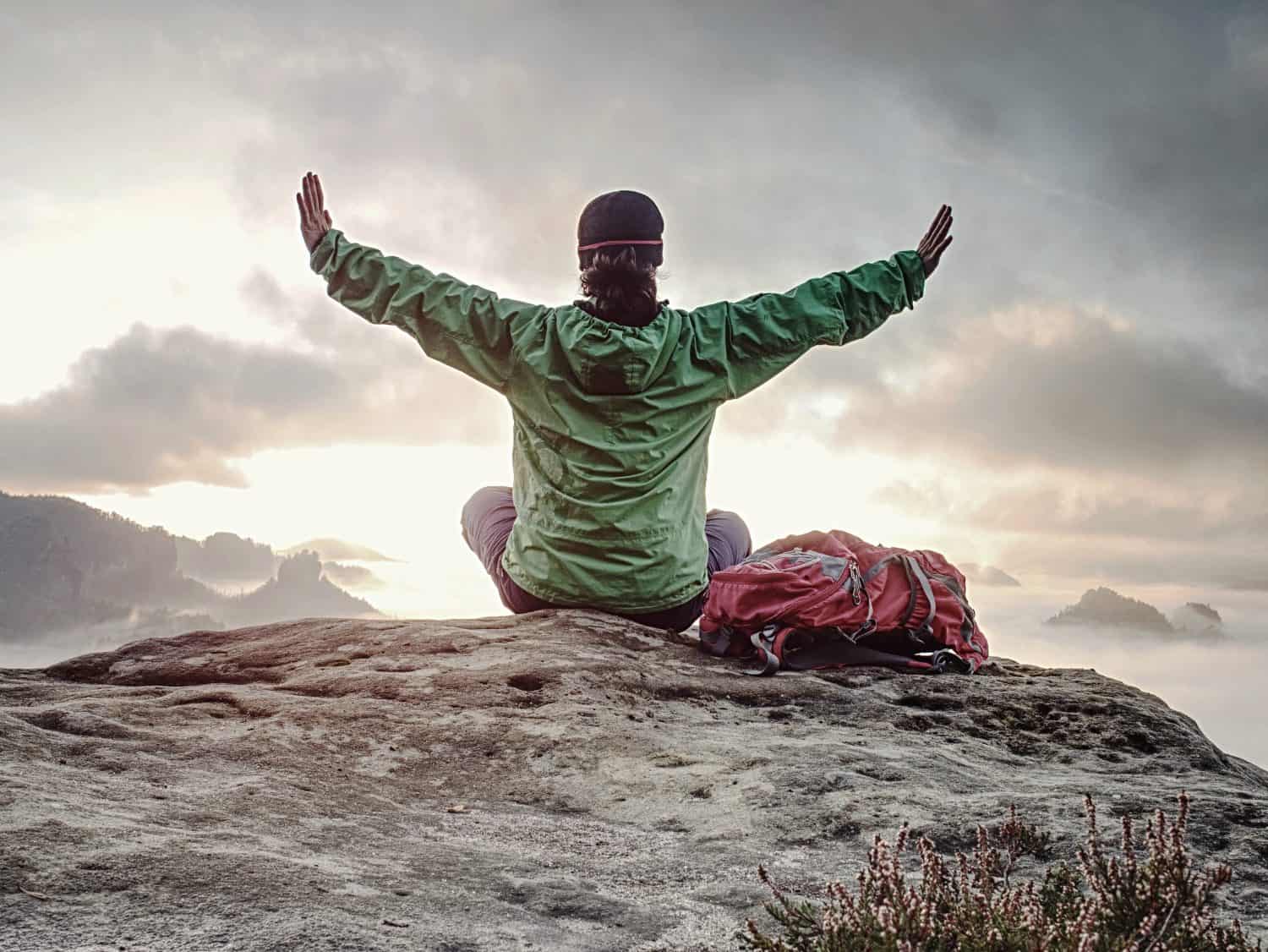 Woman just enjoying the life. Beautiful girl backpacker sitting on top of the mountain and enjoying new born of the day. Mountains landscape travel happiness emotion fall season hike.