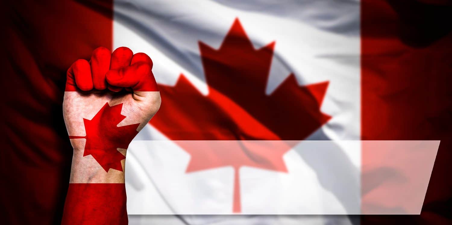 Banner of Flag of Canada painted on male fist, fist flag, country of Canada, strength, power, concept of conflict. On a blurred background with a good place for your text.