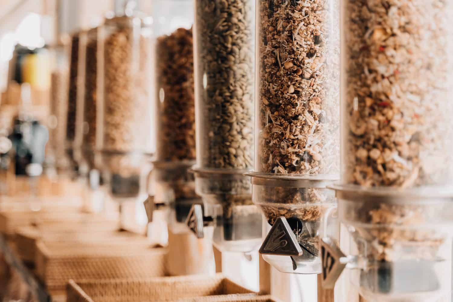 Eco-friendly zero waste shop. Dispensers for cereals, nuts and grains in sustainable plastic free grocery store. Bio organic food. Shopping at small local businesses.