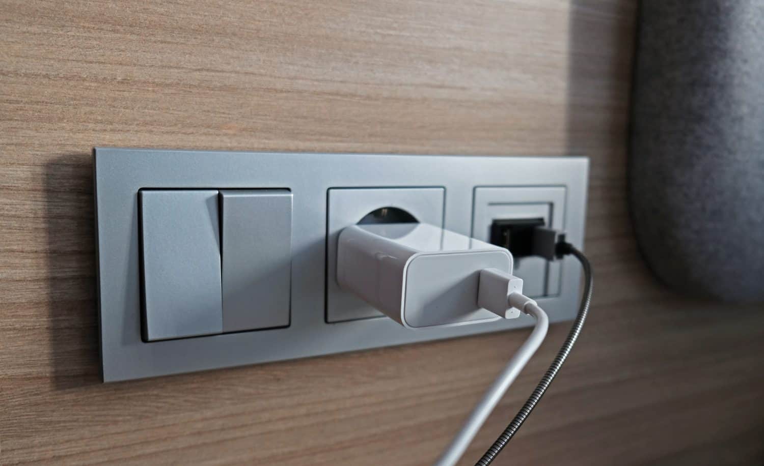 Electrical power socket, usb socket, light switch on the wood panel in the interior of the hotel. For convenience, the mobile charger or smartphone in the concept of modern life. Selective focus.