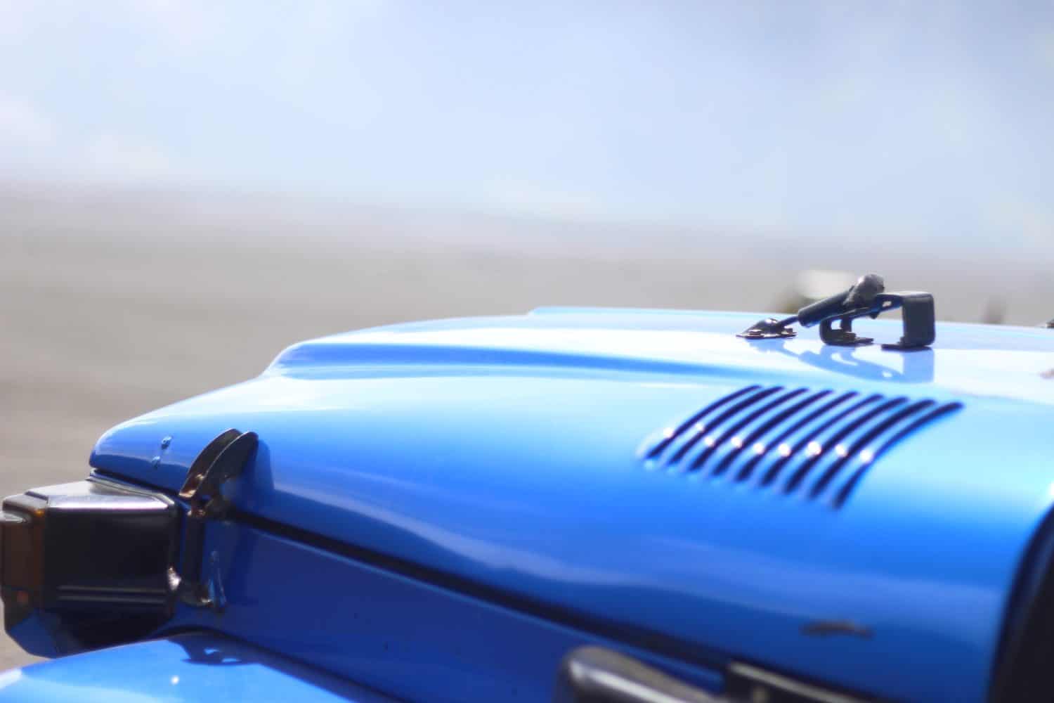 Detail of blue Jeep car in mountains.